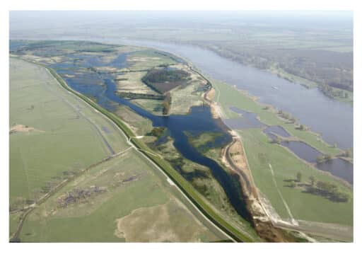 An aerial view from an airplane showing a flooded river landscape.