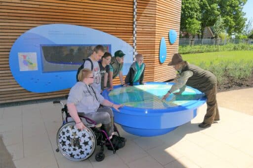 Ranger Simone Schneider explains a model to guests in the EinFlussReich open-air exhibition in Boizenburg.