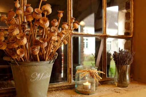 Decorative items stand in front of an old window.