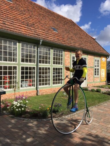 Sporty penny-farthing rider in front of the Orangery