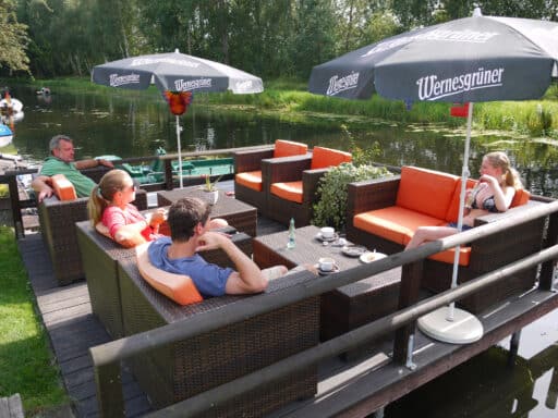 Guests sitting outside relaxing on a lounge above the canal