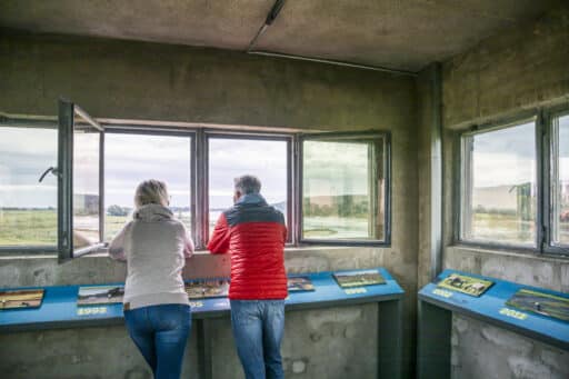 Guests look out of the window of the border tower in Darchau onto the Elbe.