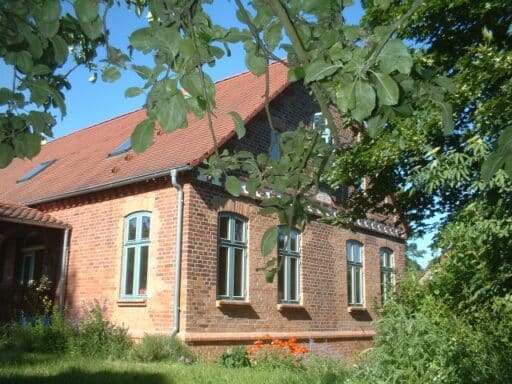 A brick house stands on the Elbe dyke.