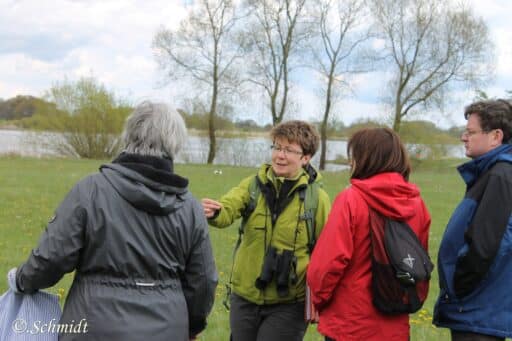 Certified nature and landscape guide Nicola Mahnke shows a group a plant.