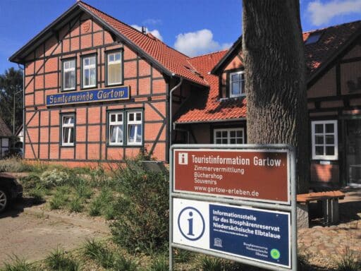 Vor dem Gebäude der Samtgemeinde Gartow steht ein Schild der Touristinformation Gartow und der Informationsstelle für das Biosphärenreservat Niedersächsische Elbtalaue.