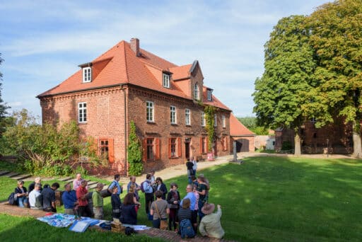 Group of visitors in front of the ZEUGHAUS information center at the Dömitz fairground.