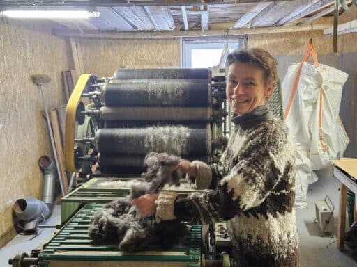Britta Eizenhöfer legt Wolle auf die Kardiermaschine