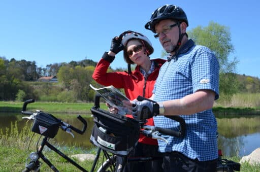 Two cyclists make a stop and look at a map.